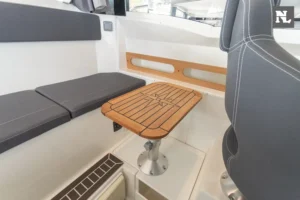 Innenraum der Parker 800 Pilothouse mit Holztisch, gepolsterter Sitzbank und sichtbarem Steuerstandssitz