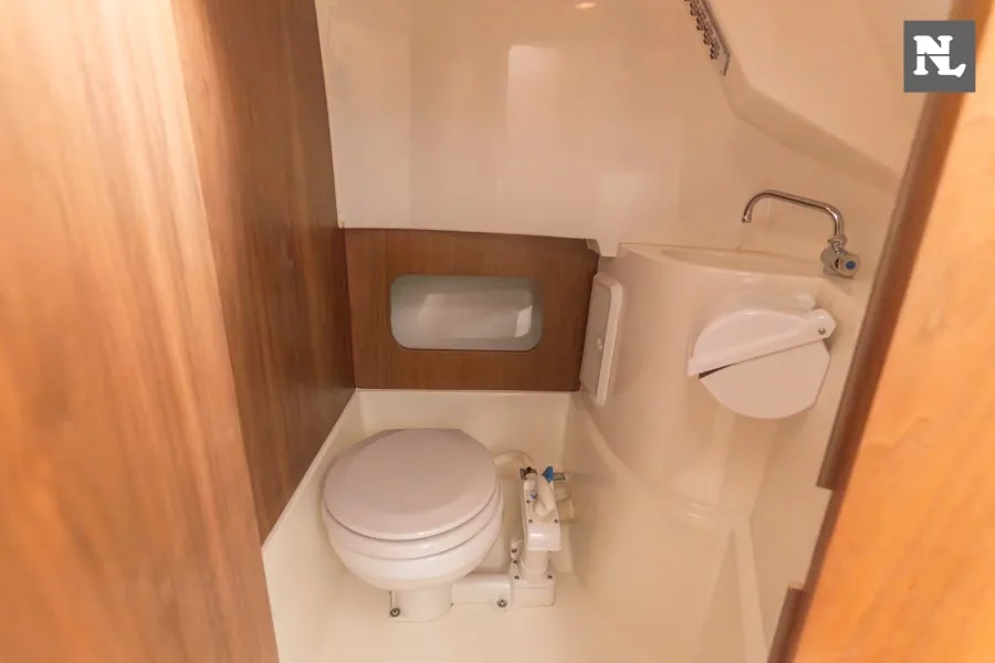 Innenraum des Badezimmers der Parker 800 Pilothouse mit Toilette, Waschbecken und Holzwänden.