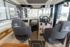 Innenraum der Parker 800 Pilothouse, Steuerstand mit zwei Sitzen, Lenkrad, Bedienelementen und Panoramafenstern.