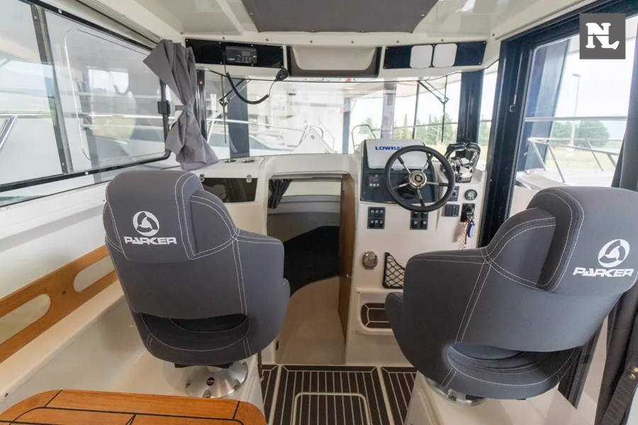 Innenraum der Parker 800 Pilothouse, Steuerstand mit zwei Sitzen, Lenkrad, Bedienelementen und Panoramafenstern.