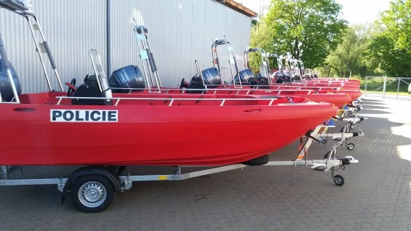 PIONER MULTI III, exterior side view of a red boat with a “POLICIE” label on a trailer.