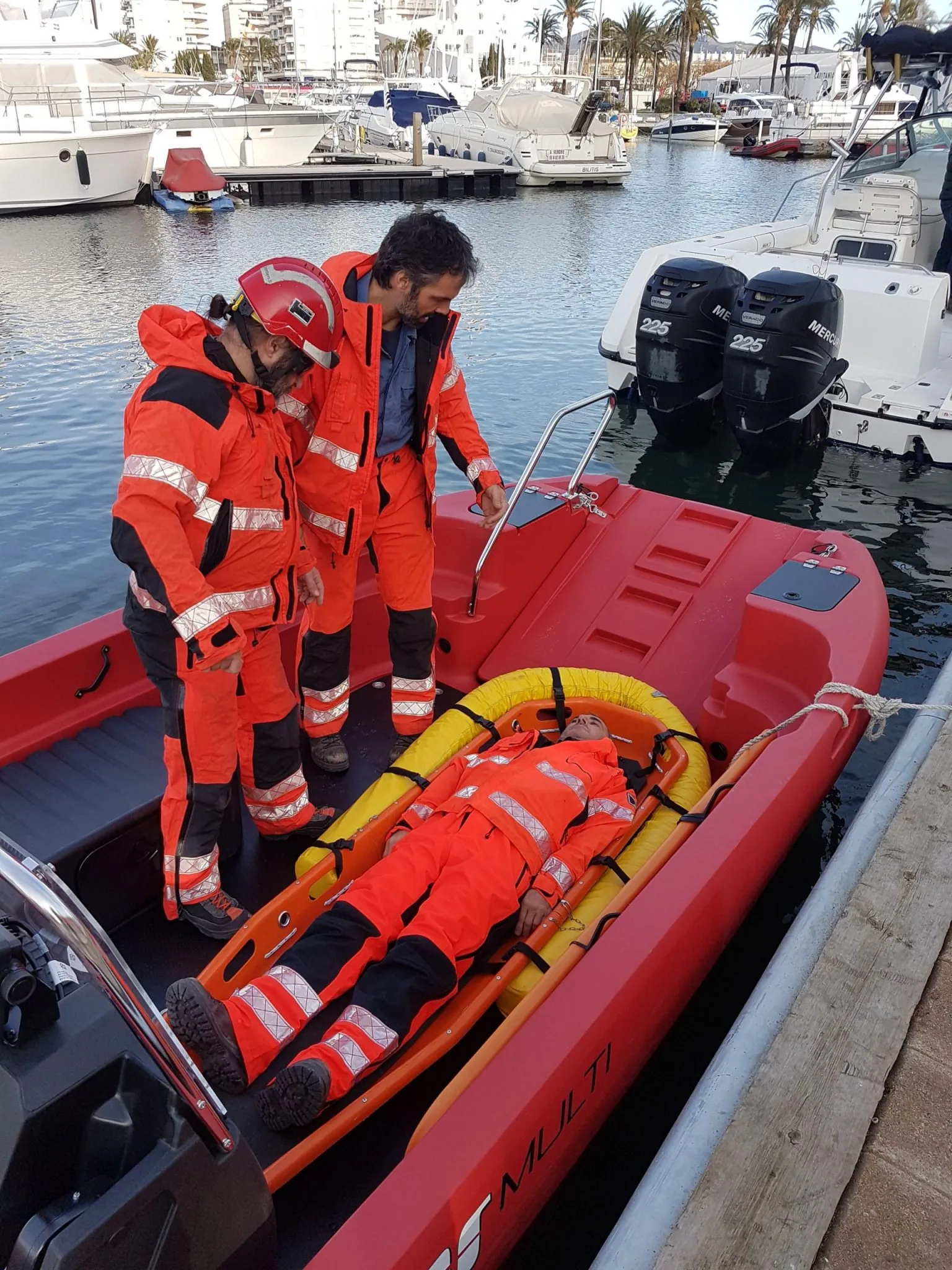 20181217_151824 PIONER MULTI III viewed from above, with two people standing and another on a stretcher, and two outboard motors next to the dock.