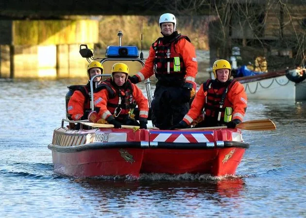 PIONER MULTI III on the water, front view, with four rescue crew members and safety equipment.