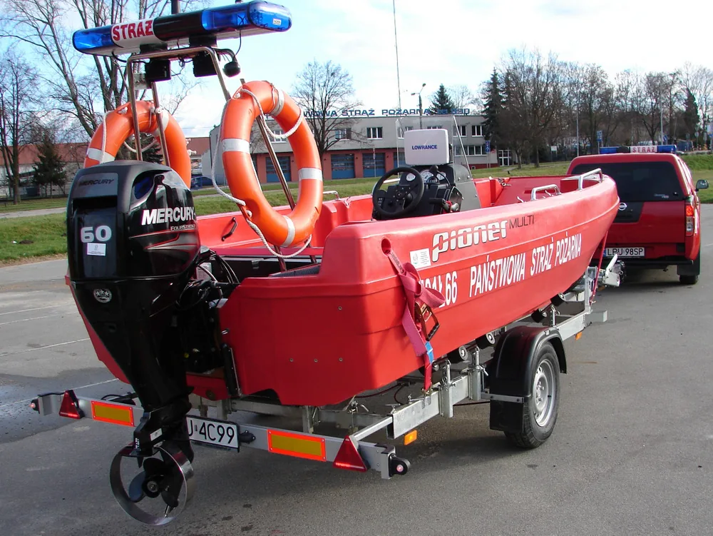 PIONER MULTI III, exterior rear-side view with outboard motor, life rings and trailer.