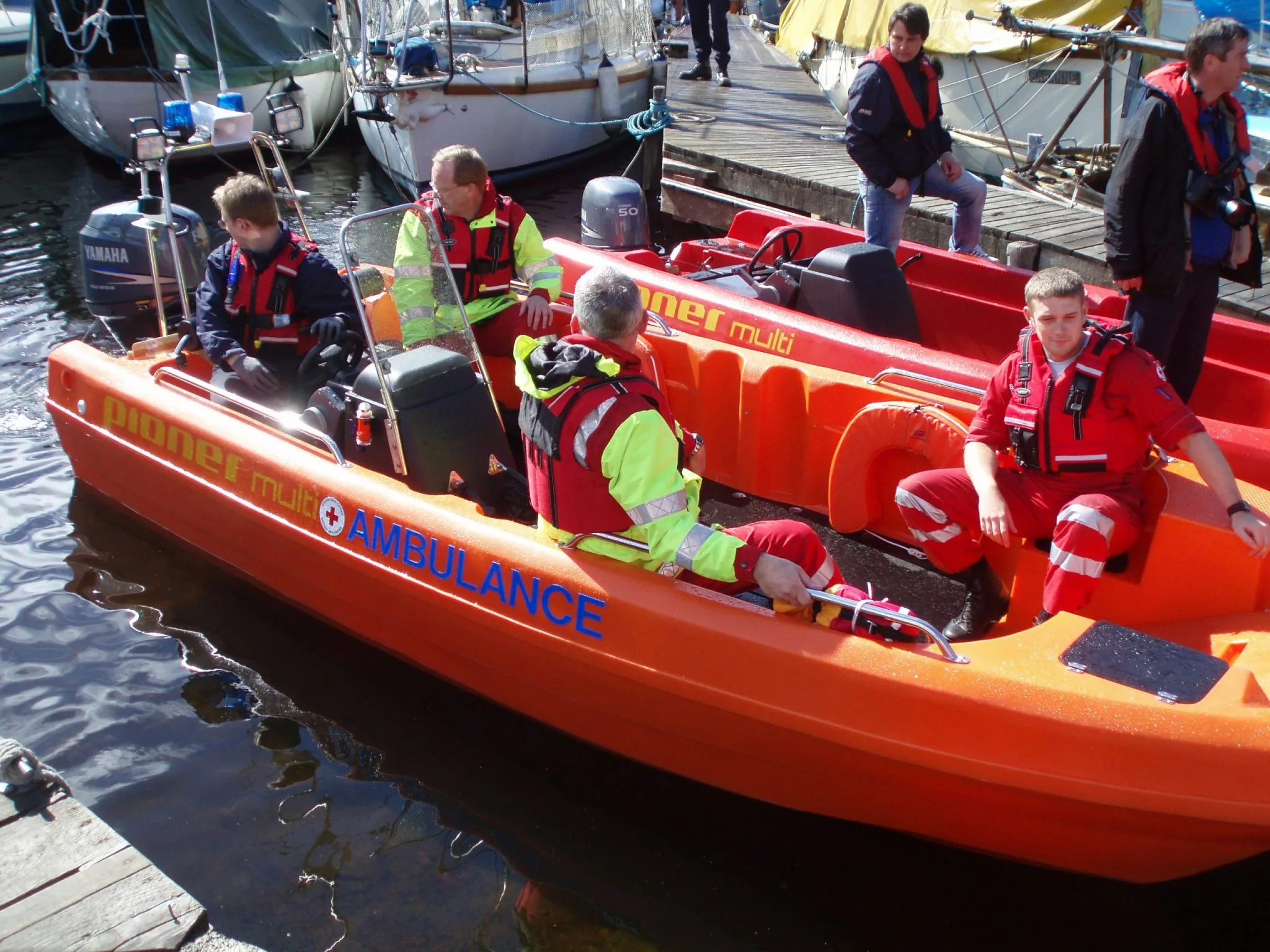 PIONER MULTI III orange, exterior side view with a nautical ambulance crew and Yamaha outboard motor.