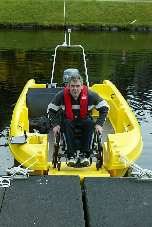multi-wheelchair-access1 PIONER MULTI III viewed from the front from the dock, with a person in a wheelchair and a center console.