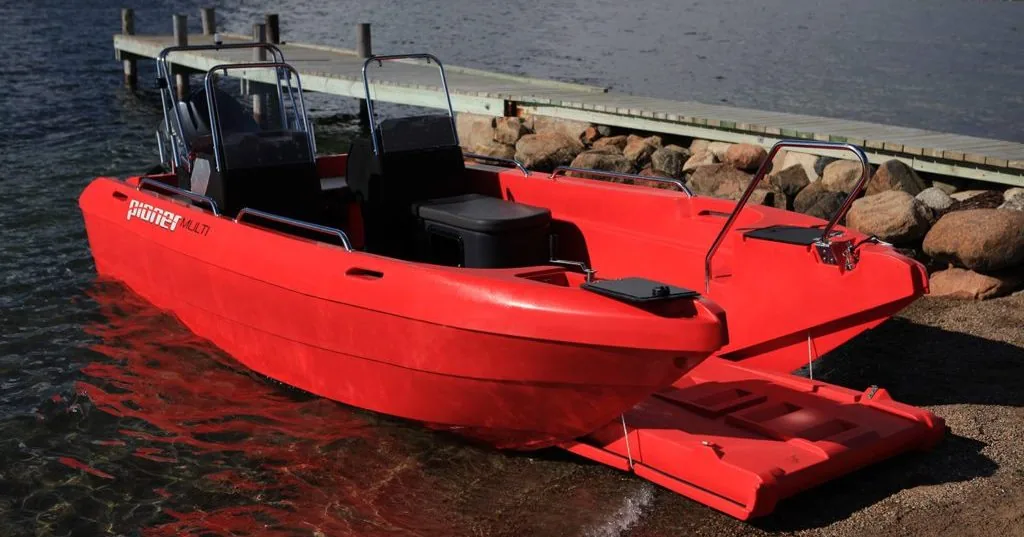 Pioner-Multi_Gallery10-1024×683 PIONER MULTI III red in profile on the water, with a center console, seats, and a folding bow platform.