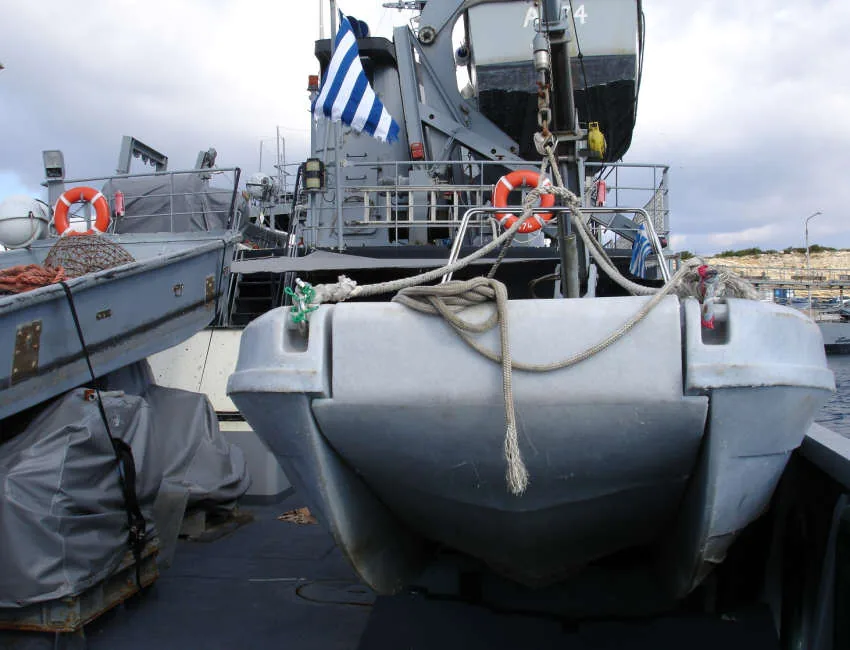 PIONER MULTI III, exterior bow view with fenders, lines, and boats in harbor.