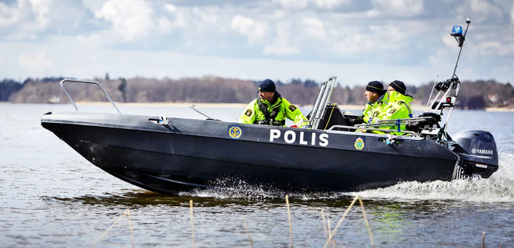 PIONER MULTI III cruising in profile, with two police officers on board and a Yamaha outboard motor