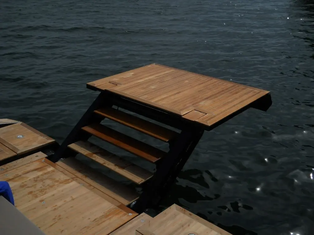 platform-transformer Outdoor wooden boating platform with folding ladders over the water, viewed from an elevated angle from the dock.