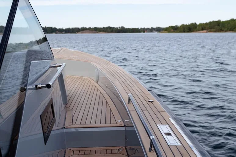 Bow deck of the Windy SR52 Blackbird viewed from the cockpit, with a teak walkway and side compartments