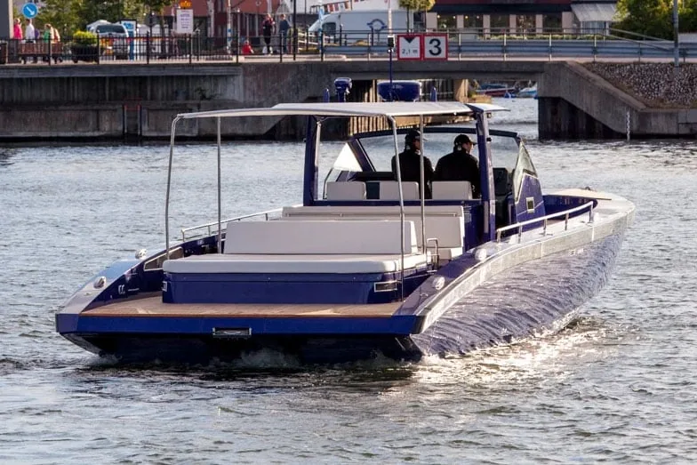 Windy SR52 Blackbird viewed from the stern, with a center console, seats, and a canopy, cruising along a canal.