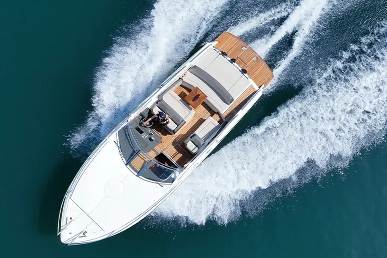 Windy 32 Grand Zonda underway, exterior aerial view with foredeck, cabin, and wake on choppy water.