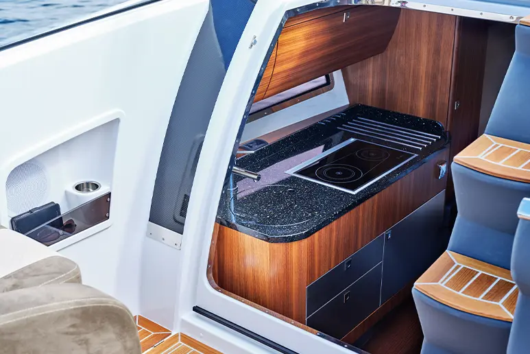 Windy 32 Grand Zonda, interior with galley, black countertop, stove and upholstered seating visible.