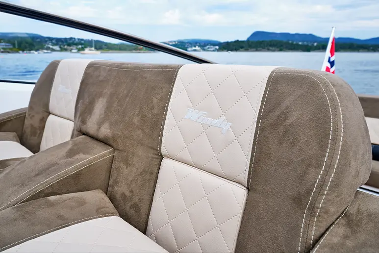 Interior of the Windy 32 Grand Zonda, detail of the two-tone upholstered seat with diamond stitching and a view of the water.