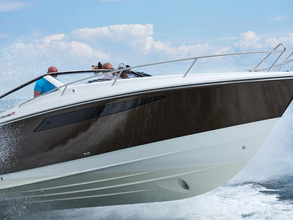 Windy 32 Grand Zonda underway, exterior side view from the bow with cockpit and passengers on board