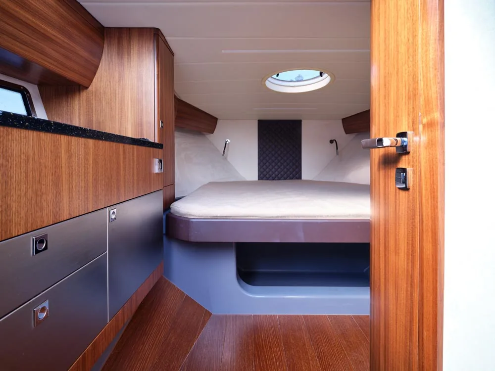 Interior of the Windy 32 Grand Zonda, view of the forward cabin with a double bed, wooden cabinets and an overhead hatch.