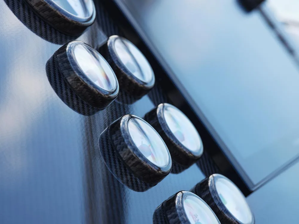 Windy 32 Grand Zonda, close-up of the control panel with circular buttons on a carbon-fiber surface