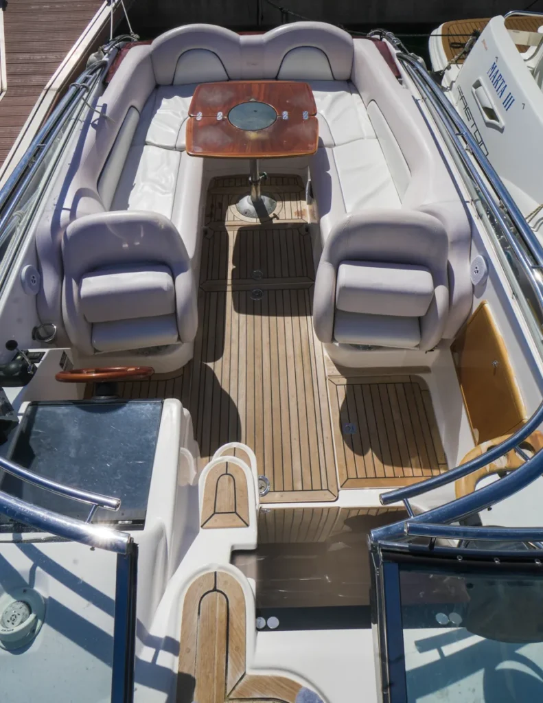 Cockpit der Windy 25 Mirage mit umlaufendem Sofa und Teakholztisch – Nautic Luis Empuriabrava