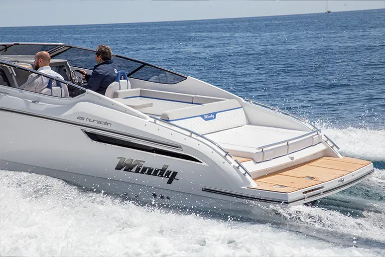 Windy 29 Huracán en navigation, vue latérale extérieure avec deux personnes, cockpit ouvert et plateforme arrière.