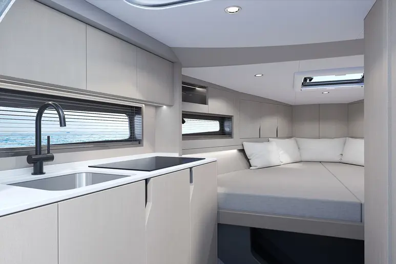Intérieur du Windy 29 Huracán, avec une cuisine équipée de deux éviers et une couchette double à l’avant.
