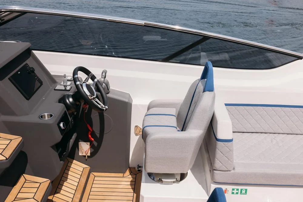 w29-galerie-2 Intérieur de Windy 29 Huracán avec console de pilotage, volant, siège du pilote et banquette latérale vus d'en haut