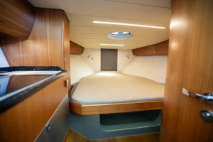 Cama doble en el camarote de la Windy 31 Zonda de ocasión en Nautic Luis, con acabados de madera y diseño escandinavo.