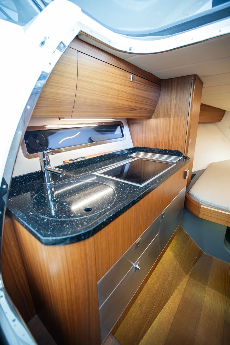 Windy 31 Zonda de ocasión cocina interior camarote Cocina interior situada en el camarote de la Windy 31 Zonda de ocasión en Nautic Luis, con mobiliario de madera y equipamiento elegante.