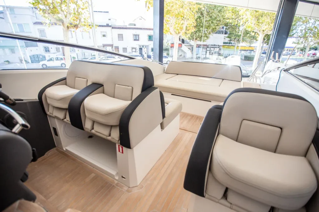 Vista hacia popa de los sillones del piloto, copiloto y tercer asiento de la Windy 31 Zonda en Nautic Luis, mostrando el diseño escandinavo y los acabados premium.