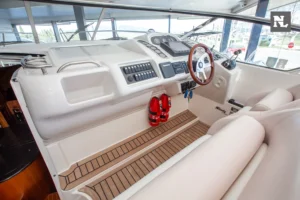 Interior del Windy 32 Scirocco visto desde popa, con puesto de mando, volante, mandos y extintores.