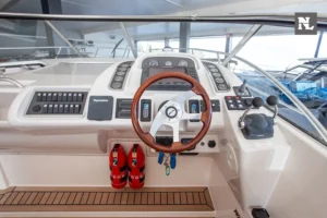 Puesto de gobierno interior del Windy 32 Scirocco, con timón de madera, controles, instrumentación y asientos.