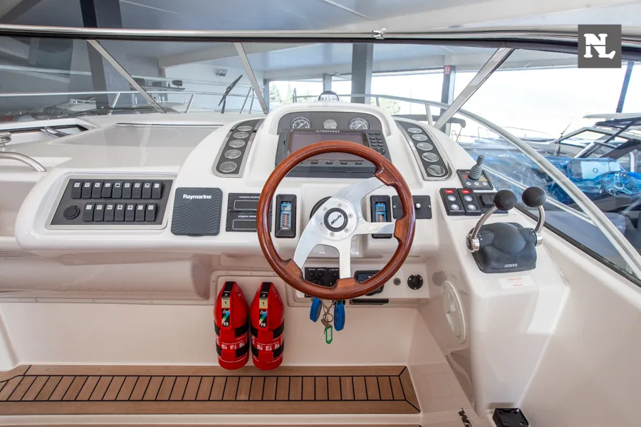 Puesto de gobierno interior del Windy 32 Scirocco, con timón de madera, controles, instrumentación y asientos.