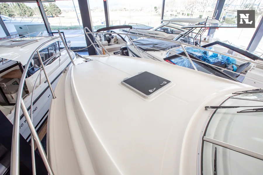 Cubierta de proa del Windy 32 Scirocco, vista exterior con escotilla, pasamanos y embarcaciones en marina techada