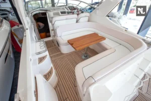 Interior del cockpit del Windy 32 Scirocco, con asientos, mesa de madera, puesto de mando y suelo de teca.
