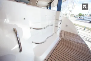 Cubierta exterior del Windy 32 Scirocco, vista lateral con pasamanos, escalones y suelo de teca.