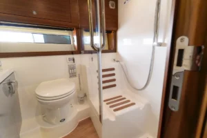 Baño de la Windy 37 Shamal de segunda mano en Nautic Luis, Empuriabrava, con lavabo, espejo y acabados de lujo en madera y acero.