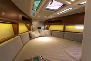 Cama doble del camarote principal de la Windy 37 Shamal de segunda mano en Nautic Luis, Empuriabrava, con iluminación cálida y acabados en madera natural.