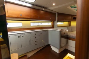 Galley de la Windy 37 Shamal de segunda mano en Nautic Luis, Empuriabrava, con múltiples armarios y cajones de almacenamiento en madera.