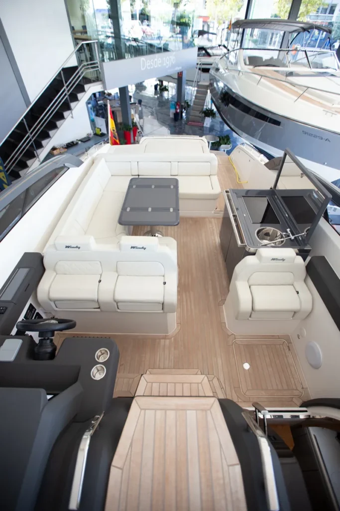 Vista completa de la bañera de la Windy 37 Shamal de segunda mano en Nautic Luis, Empuriabrava, mostrando el sofá en U, la mesa y la cocina exterior.