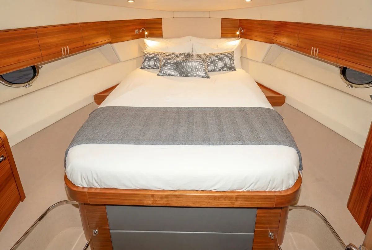 Cabina del armador con cama doble central y acabados en madera. Eignerkabine im Bug der gebrauchten Windy 46 Chinook mit Mittelbett – Nautic Luis Empuriabrava