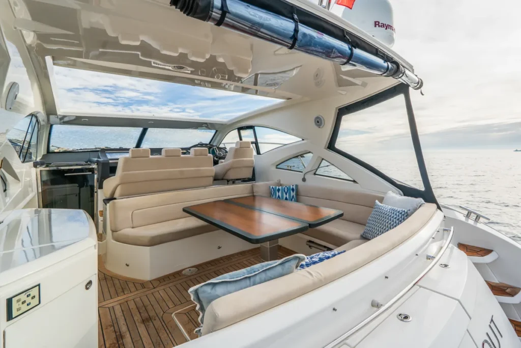 Außencockpit der gebrauchten Windy 46 Chinook mit U-förmigem Sofa und Teakholztisch – Nautic Luis Empuriabrava