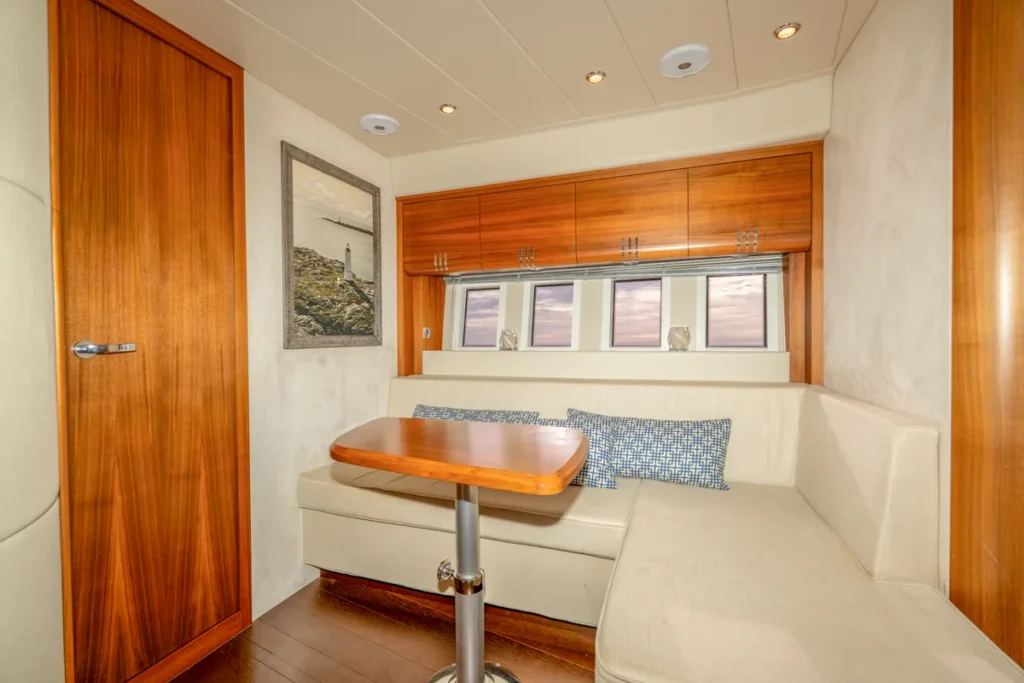 Innenraum der gebrauchten Windy 46 Chinook mit L-förmigem Sofa und zentralem Tisch – Nautic Luis Empuriabrava