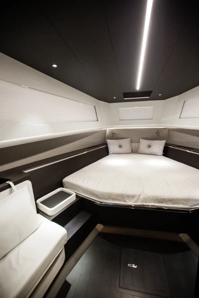 Cama doble del camarote de proa con uno de los dos asientos laterales