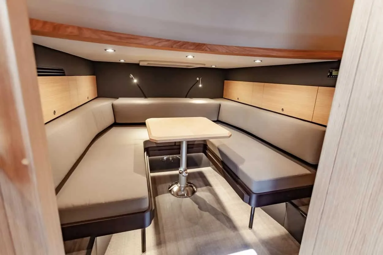 Interior of the Windy SR52 Blackbird with lounge, central table, side sofas and wooden cabinets.